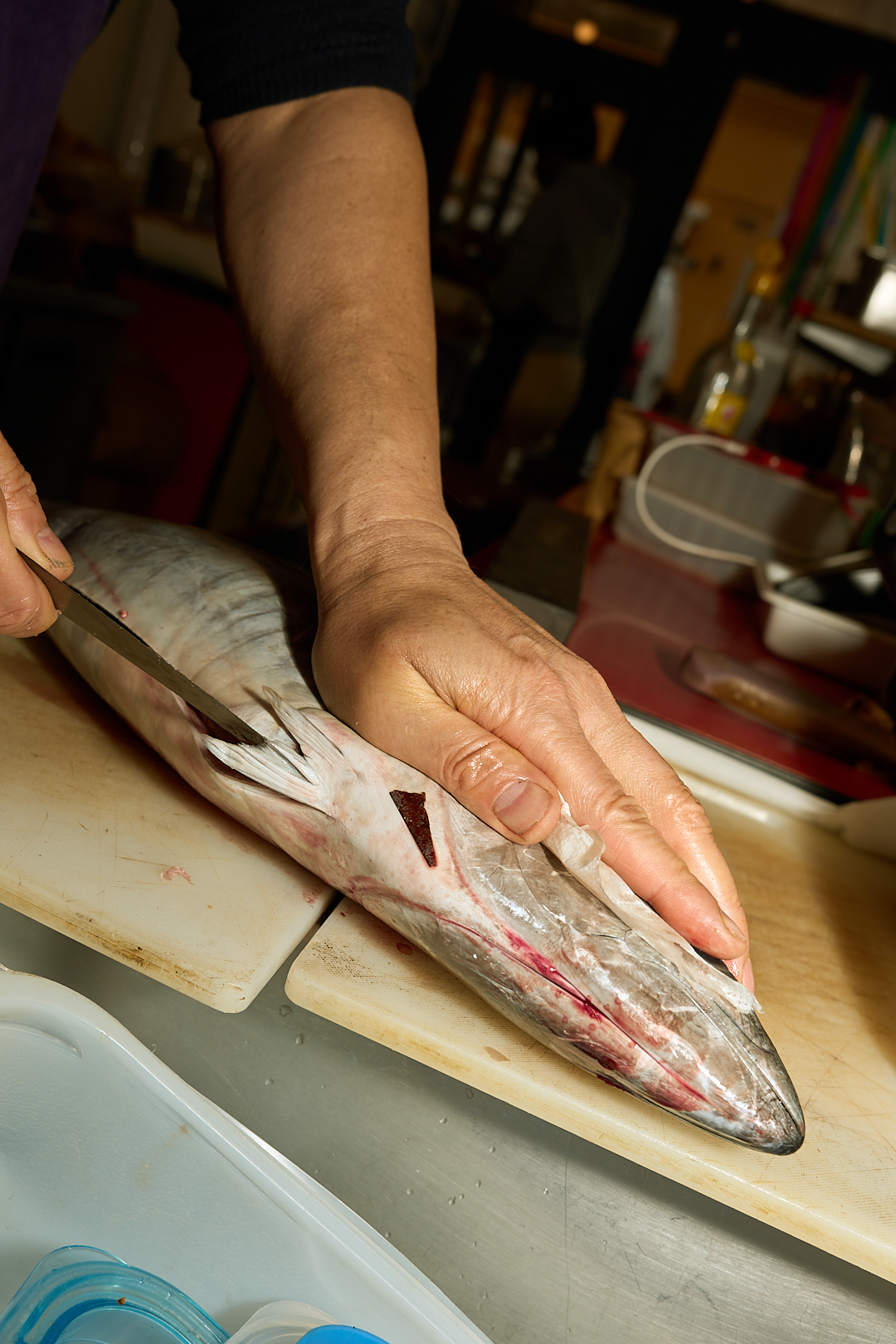 Christian Qi prépare un poisson en cuisine